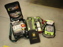 Hoitovälinelaukku, happi, defibrillaattori ja kansio, jonka kulmassa häkämittari.